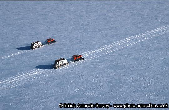 Aerial view of two sno-cats transporting empty drums from Halley Research Station to the ship for crushing and disposal outside Antarctica