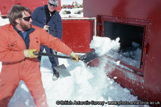 Shovelling snow into the melt tank of the Drewry Building to provide fresh water for washing, drinking and cooking.