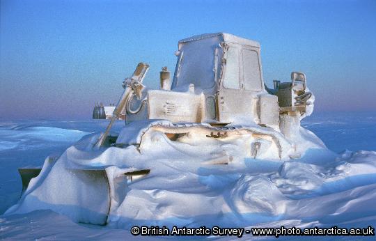 The reality of winter at Halley research station where temperatures may drop below -50 degrees Celsius.  An International Harvester Bulldozer is encased in a frost of spin-drift and drifted snow through the winter of 1995.  Once the bulldozer's engine preheaters are switched on, the vehicle could be running in an hour.