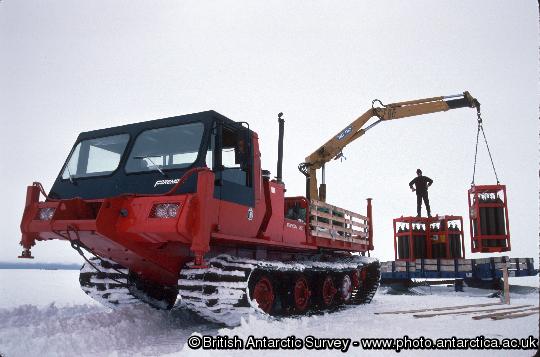 Nodwell 110c fitted with crane unloading Helium bottles