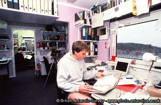 Bird Assistant Daf' Roberts logs the days albatross nest round data in the main office room  at Bird Island