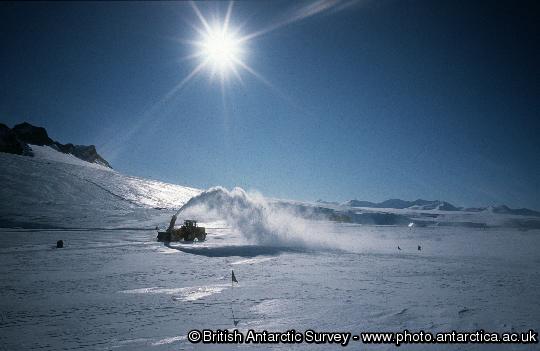 Snow Blower clearing clearing snow on the runway with reptile ridge in the background.
