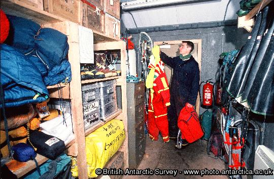 Bird Assistant Daf' Roberts hangs up small boat suits in the 'outdoor clothing and rescue store' at Bird Island