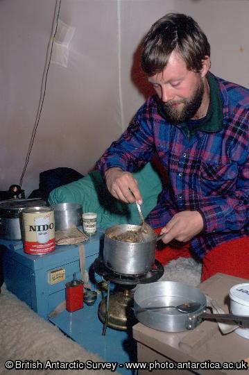 Preparing a meal inside a pyramid tent