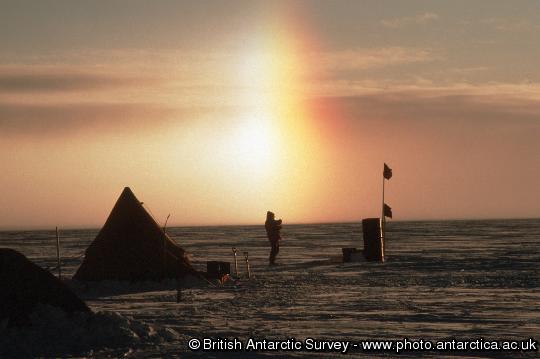 Sun dog formed in light falling snow  The light from the sun is refracted by the ice crystals to form parhelia, or sun-dogs.
