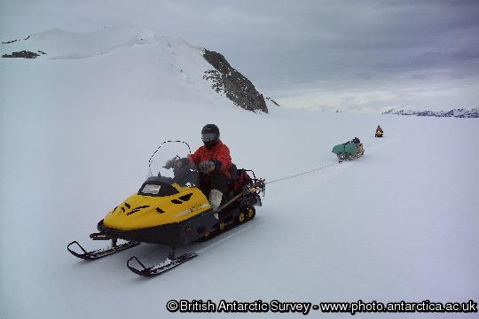 Two-man skidoo team roped together for safe field travel.