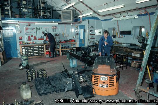 Mechanic working on a ski-doo in the garage at Rothera Research Station. Snow-mobiles are extensively used at the BAS stations and at remote field locations. These small vehicles are used for personal transport and for towing Nansen sledges. BAS operates Bombardier Ski-doos which are simple to ride with just a twist grip throttle and a brake. They have a fully automatic transmission and a track underneath with skis at the front to steer. Ski-doos can attain speeds of up to 50 mph on smooth snow.