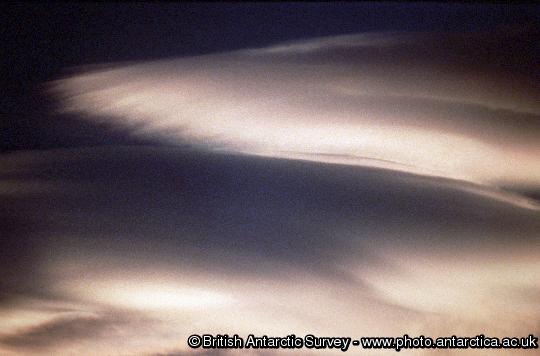 Wave clouds, also known as 'stack of plate' clouds.  These are formed by air being forced to rise over a mountain range, with the moister layers condensing to form cloud.