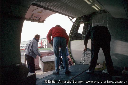 Dash 7 aircraft showing cargo being unloaded through the cargo door at Stanley Airport in the Falkland Islands