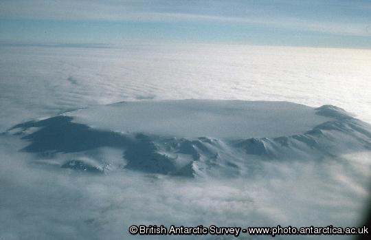 Aerial view pf the 5-6 Km Diameter Ice-filled summit caldera and upper slopes of Mt Hampton, a mid-Miocene alkaline stratovolcano in the Executive Committee Range, investigated by British and American geologists as part of the WAVE (West Antarctic Volcano Exploration) project.