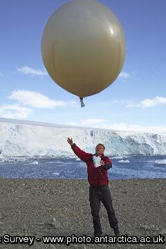A scientist launches a meteorological balloon at Rothera Research Station.