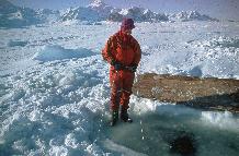 Linesman (Stuart Wallace) monitoring life line for divers working under one metre thick fast ice winter 1997.