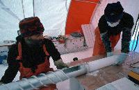 International European Project for Ice Coring in Antarctica (EPICA) project: Dronning Maud Land reconnaissance phase.  Scientists remove a core from the barrel of an ice core drill: analysis of the ice, which fell as snow more than 1000 years ago, will reveal changes in climate and the composition of the atmosphere.