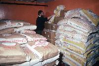The Rothera cook and sacks of flour in the food store at Rothera.
